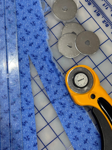 Cut fabric next to rotary blades and cutter